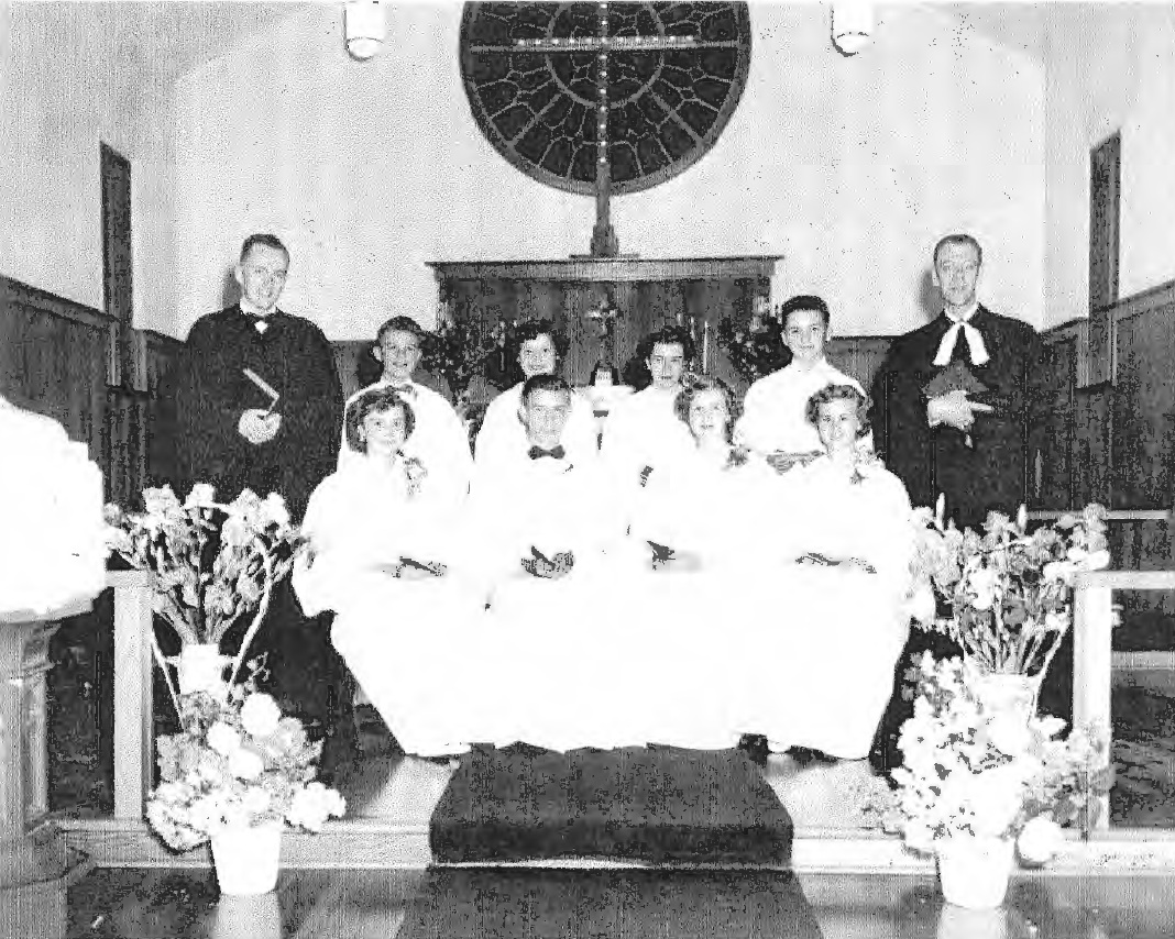 Historic black and white photograph of the first confirmation class at Trinity Lutheran Church in 1954, showing the students and clergy in the sanctuary of Bethlehem Lutheran Church in Vancouver, BC