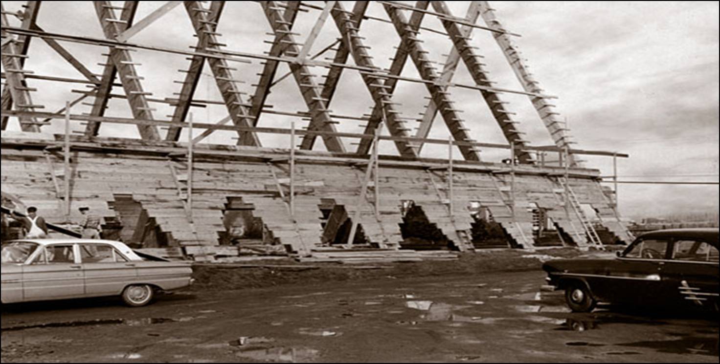1964  historic photograph of the side elevation of Trinity Lutheran Church during construction in Richmond. Horizontal wooden decking is being installed over the A-frame structural skeleton.
