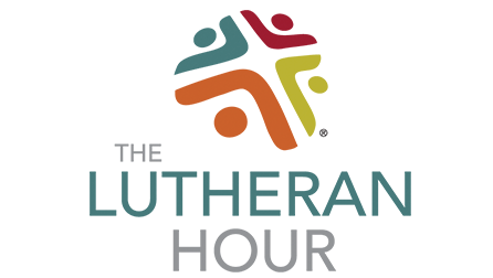 Logo for The Lutheran Hour, featuring a colourful, stylized cross at the top composed of four interlocking human figures in teal, red, orange, and lime green. Below the emblem, the text THE LUTHERAN HOUR is displayed, with LUTHERAN in a larger, darker teal and THE and HOUR in a lighter grey.
