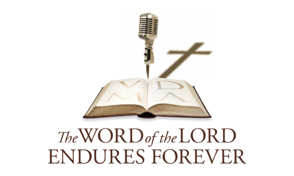 Logo for The Word of the Lord Endures Forever, featuring an open Bible with the gold letters VDMA across its pages. A vintage-style silver microphone stands behind the Bible, casting a shadow in the shape of a Christian cross. Below the image, the title The WORD of the LORD ENDURES FOREVER is written in maroon.