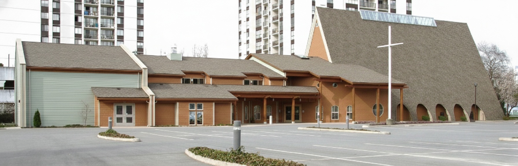 Side profile of Trinity Lutheran Church in Richmond, BC, showing the connected multi-use facility and the large on-site parking lot available for visitors and members. The church is across the street from Minoru Park.